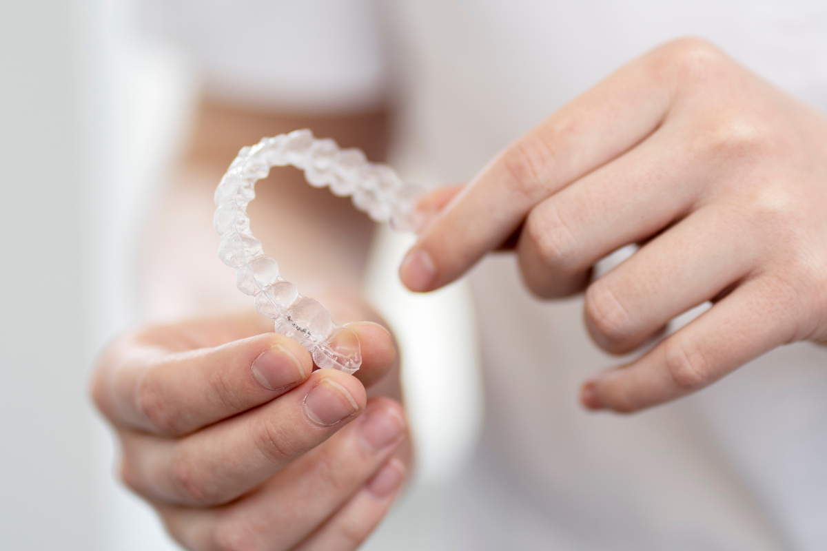 Patient holding clear aligners at dental consultation