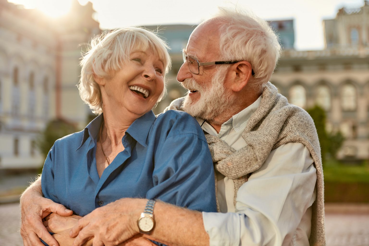 Feeling happy with you. Cheerful senior couple in casual clothing embracing each other and laughing while standing together outdoors Feeling happy with you. Cheerful senior couple in casual clothing embracing each other and laughing while standing together outdoors. Love concept. Family
