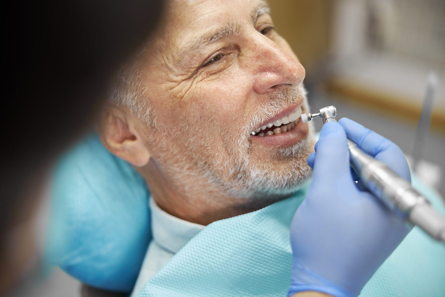Senior man smiling while being treated by a dentist Cropped photo of an elderly citizen getting his teeth fixed by a dentist